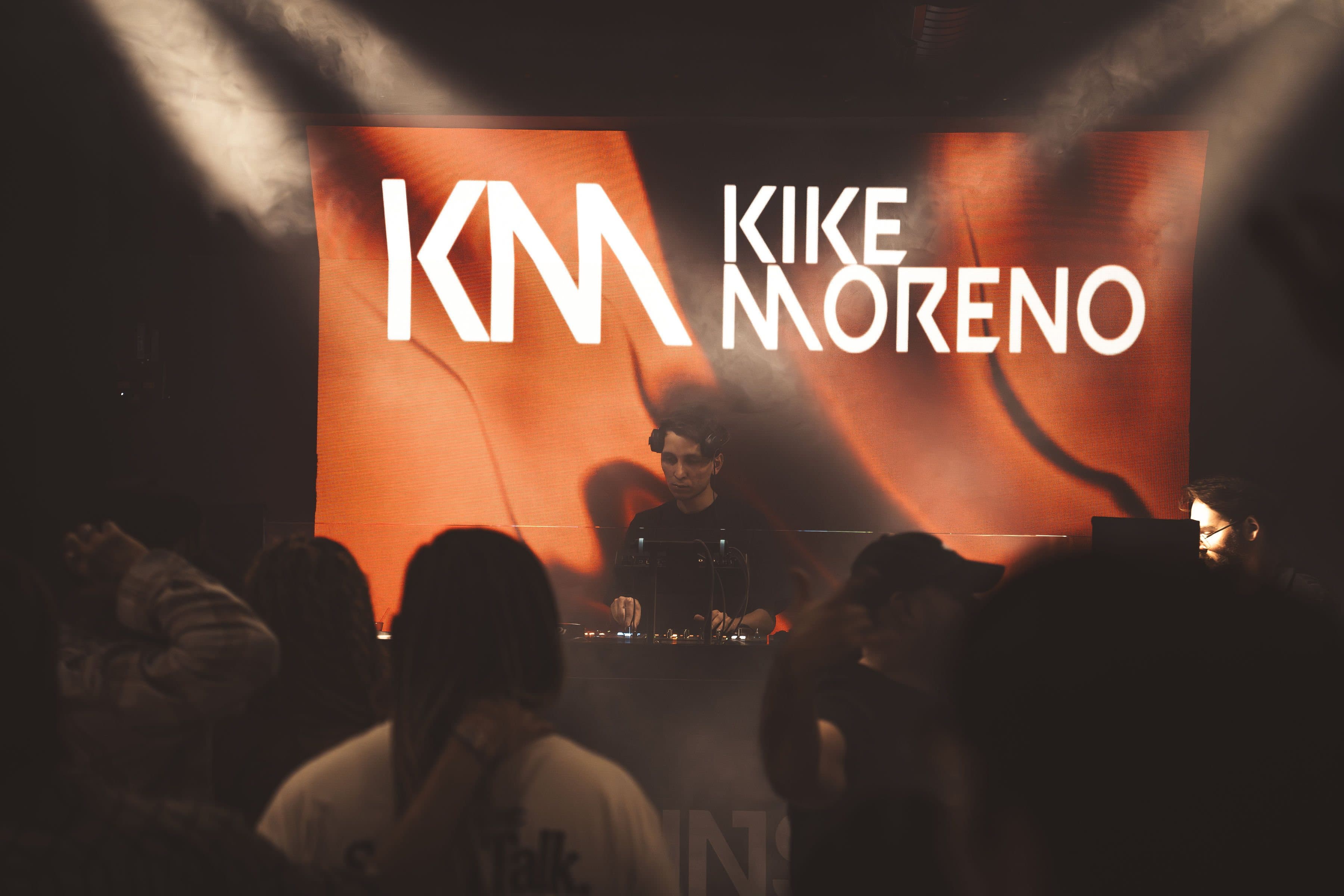 Kike Moreno behind the decks, his KM artwork glowing on the LED wall above a full room